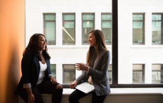 Zwei Frauen sitzen sich gegenüber und unterhalten sich darüber wie man Japanisch sprechen lernen kann