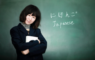 Eine Japanisch-Lehrerin steht vor einer Tafel