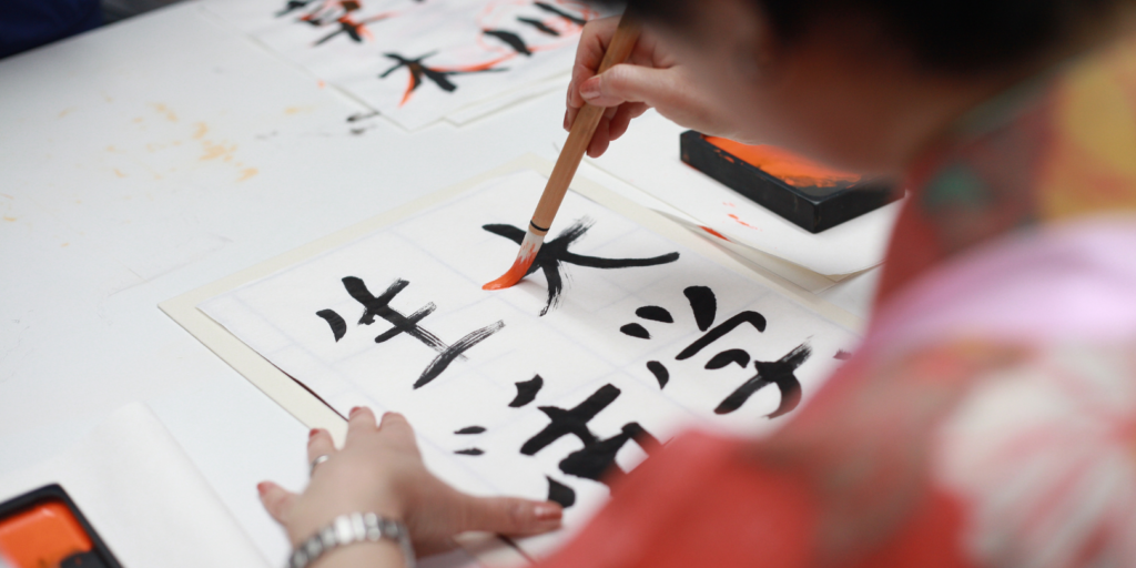 Japanerin zeichnet japanische Schriftzeichen