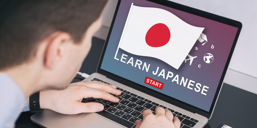 Mann sitzt vor Laptop und lernt die japanische Sprache
